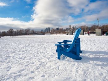 Snow covered land on field against sky