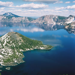 Aerial view of sea and snowcapped mountains against sky