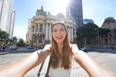 Brazilian young woman takes self portrait in front of the municipal theater of rio de janeiro,brazil