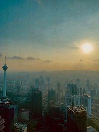 Aerial view of buildings in city at sunset