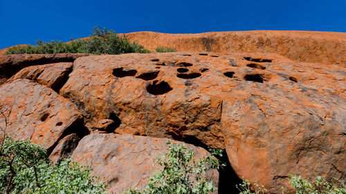 Rock formations on landscape against clear blue sky