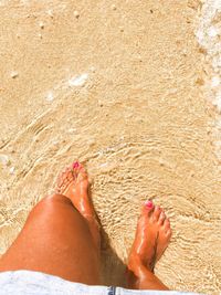 Low section of woman standing at beach