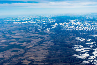 Aerial view of snowcapped landscape against sky