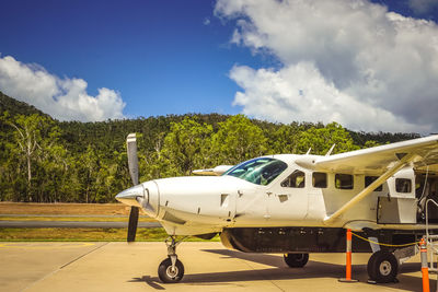 Airplane on airport runway against sky