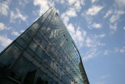 Low angle view of modern building against cloudy sky