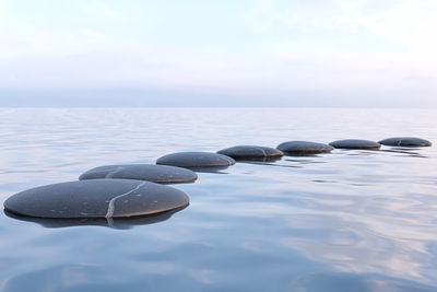 Close-up of pebbles on sea shore against sky