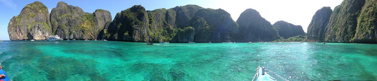 Panoramic shot of calm sea against rocky mountains