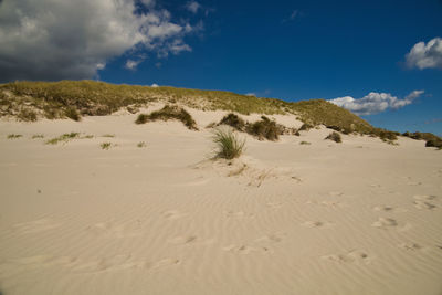 Scenic view of sand dunes against sky