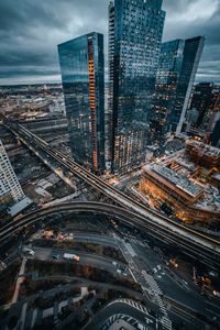 High angle view of city buildings against cloudy sky