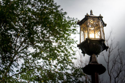 Low angle view of illuminated street light against sky