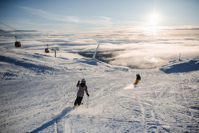 People on snow covered mountain against sky