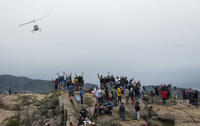 Group of people on runway against sky