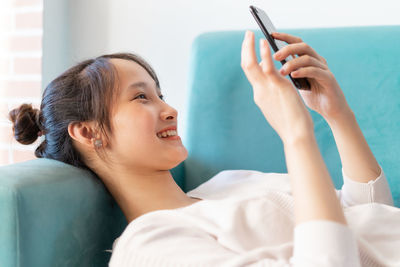 Young woman using mobile phone at home