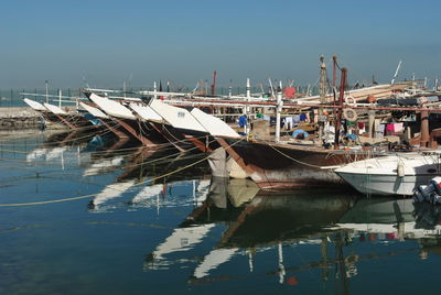 Boats moored on shore against sky