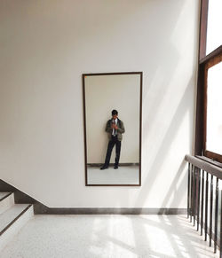 Portrait of man standing on staircase at home