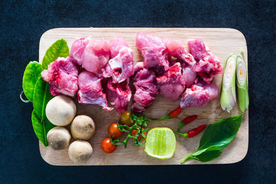 Directly above shot of vegetables and meat on cutting board over table