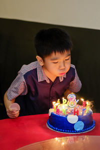 High angle view of boy with coffee on table