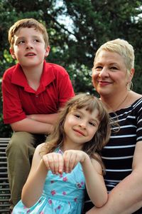 Smiling mother with children against plants