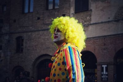Woman standing against multi colored building
