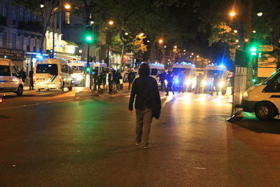 Rear view of man on city street at night