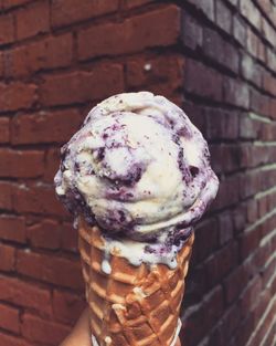 Close-up of ice cream cone against brick wall