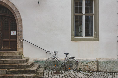 Bicycle leaning against wall of building