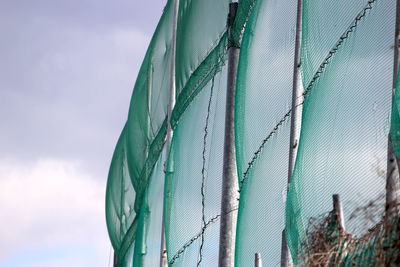 Low angle view of fence against sky