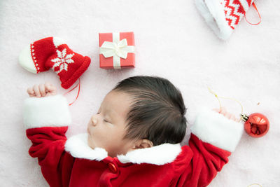 High angle view of baby girl lying on bed