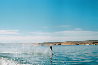 Man surfing in sea against sky