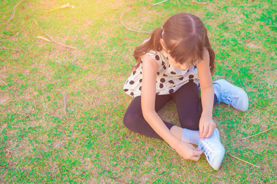 High angle view of girl sitting on grass