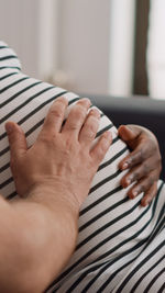 Midsection of couple hands on bed