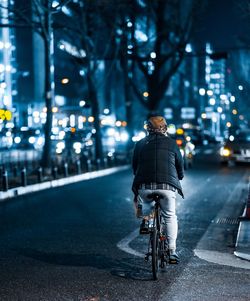 Rear view of man riding bicycle on street