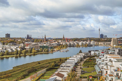 High angle view of river amidst buildings in city against sky