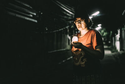 Full length of young woman holding lamp 