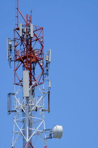 Low angle view of communications tower against clear blue sky