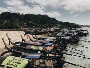 High angle view of fishing boats moored at harbor against sky