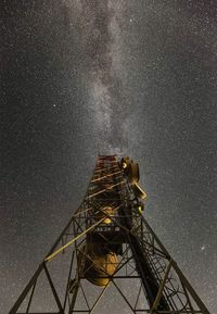 Low angle view of illuminated tower against sky at night