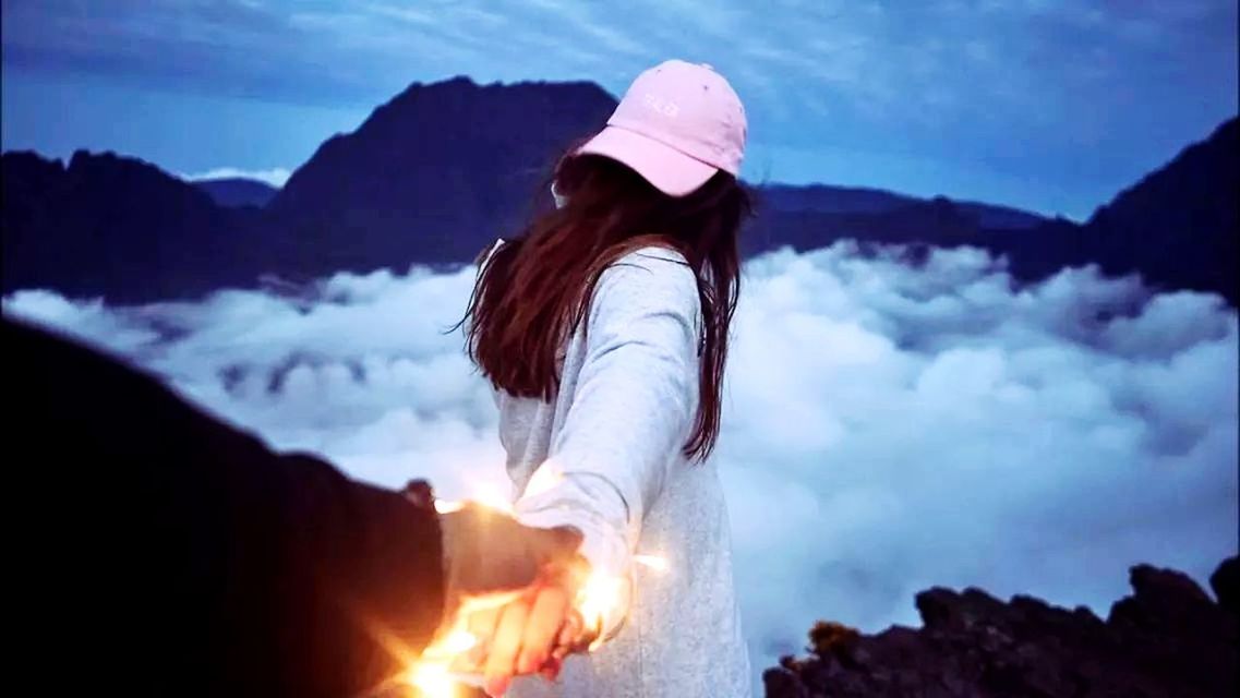 WOMAN STANDING AGAINST MOUNTAIN