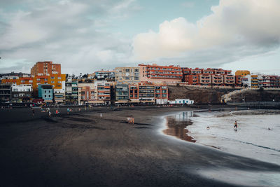 People enjoying at beach in city