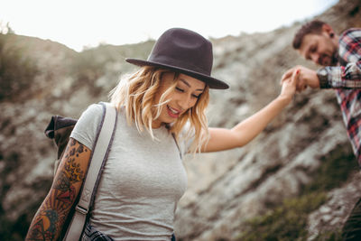 Man holding hand of woman while walking on mountain