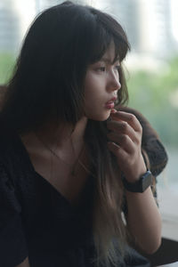 Close-up of young woman looking away indoors