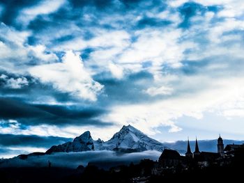 Scenic view of snowcapped mountains against cloudy sky