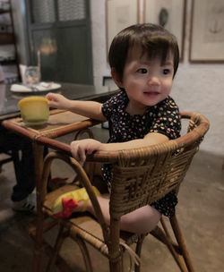 Cute baby girl looking away while sitting at home