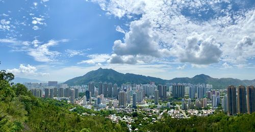 Panoramic view of buildings against cloudy sky