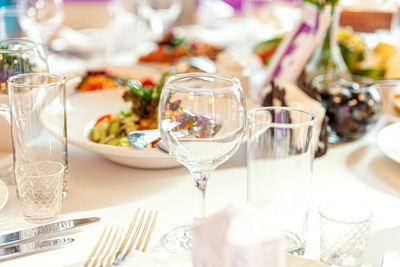 Fancy table set for dinner with napkin glasses in restaurant, luxury interior background