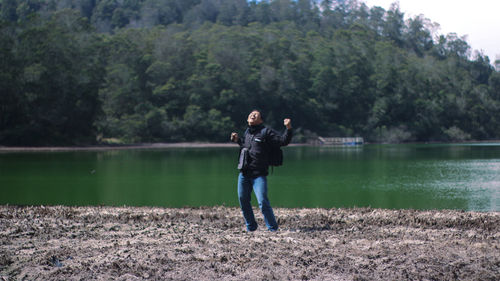 Full length of man standing by lake