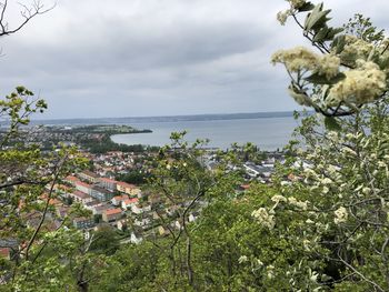 Scenic view of sea by townscape against sky