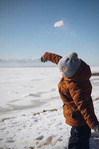 Rear view of man standing on snow covered land