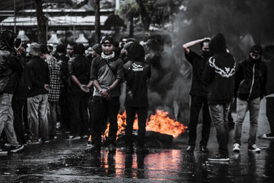 Group of people on wet sidewalk during rainy season