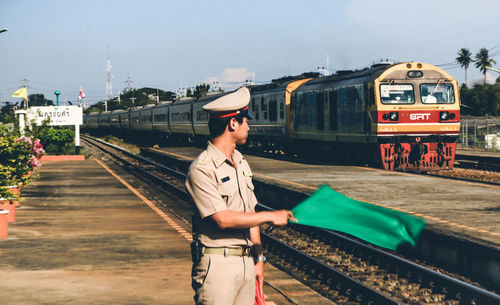 Man standing on train at railroad station